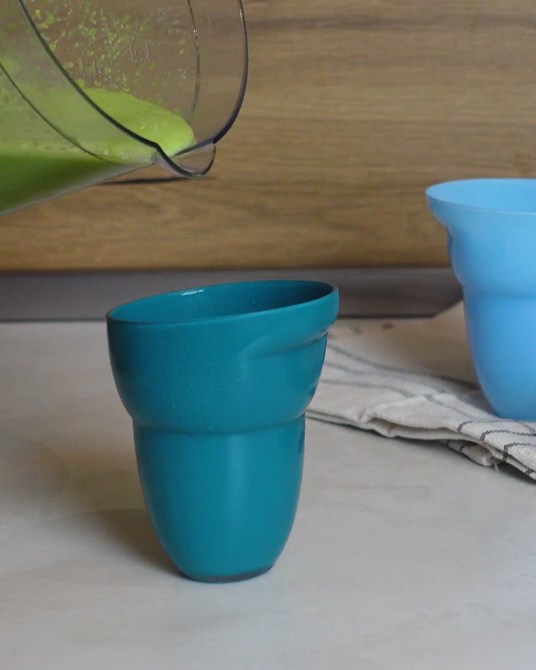 Green smoothie in teal green, heaven blue glass and rose color porcelain cups.